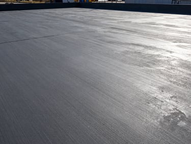 Wide shot of a completed, smooth-troweled concrete slab at the Riverbend Logistics Hub, high-contrast morning light, industrial setting, 35mm lens.