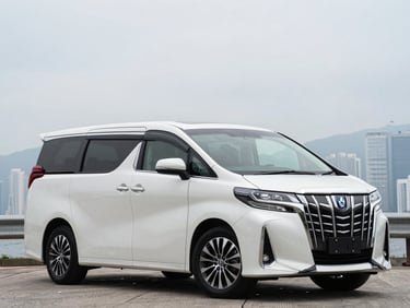 Front three-quarter driver-side profile of a white Toyota Alphard, overcast Hong Kong daylight, full vehicle visible, squared frame, no tilt