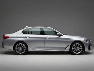 Front three-quarter driver-side profile of a silver BMW 5 Series sedan, studio strobe lighting, full vehicle visible, squared frame