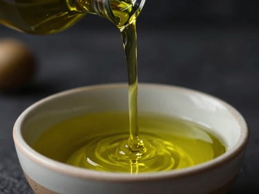 Close-up of vibrant green olive oil being poured into a shallow ceramic bowl, catching warm golden light, elegant dark background.