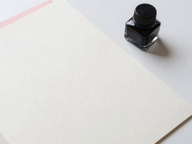 Overhead flat-lay of a minimalist writer's desk, heavy-weight cotton paper stock, a glass ink well, soft morning daylight, sharp focus, 35mm