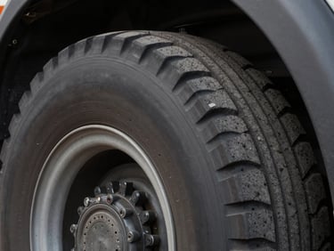 Extreme close-up of a heavy bus or truck tire cross-section showing sealant coating the inner wall, studio strobe lighting, matte black tire rubber, technical precision detail, no people