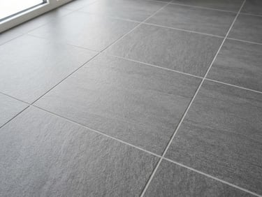 Close-up of perfectly aligned modern large-format gray tiles with crisp grout lines, bright natural daylight