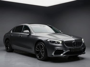 Wide studio shot of a luxury sedan fully wrapped in deep satin charcoal, three-quarter front angle under controlled overhead strobes, the surface tension of the vinyl visible in the sculpted body lines, clean dark background with no distractions