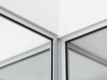 Macro shot of a perfect double-glass partition joint with dark aluminum profile, sharp focus, clean lines, bright white architectural light