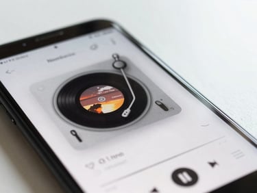 Macro shot of an Android phone screen playing music in a clean media player app, album art visible, shallow depth of field, bright daylight.
