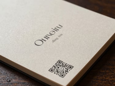 A thick, textured paper menu card with elegant typography and a clear scan-to-order QR code at the corner.