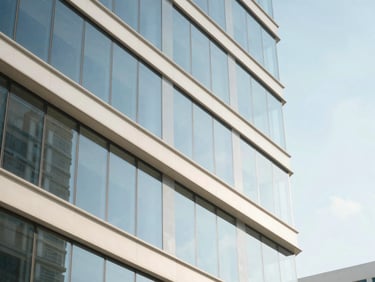 Abstract architectural detail of a modern glass office building in Miami reflecting a bright blue sky, clean geometric lines, high-key daylight.