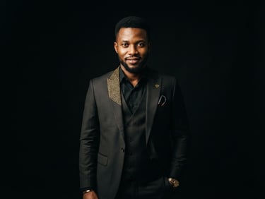 Cinematic portrait of a confident young Equatoguinean tech entrepreneur in a tailored dark suit with gold lapel details, dramatic studio lighting, deep black background