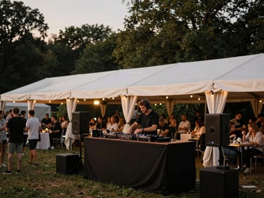 Dynamic shot of a professional DJ setup under warm stage lighting within a large event tent, subtle audience interaction, elegant atmosphere, twilight.