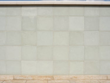editorial architectural photography of massive porcelain panel installation on a coastal wall, seamless joints, bright natural daylight