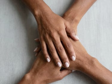 Elegant French tip manicure on long almond-shaped nails held by a person with dark skin.