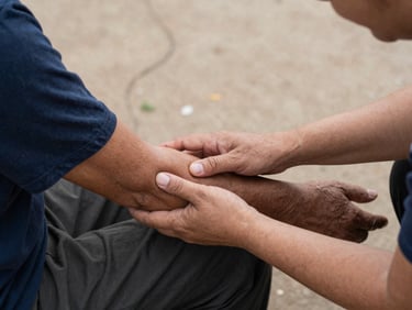 Hands clasped in support, a volunteer gently touching the arm of a recovering individual, warm, candid, documentary style, natural light.