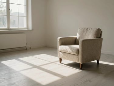 Medium-wide environmental shot of a peaceful, empty consultation room, soft shadows cast by window panes on a white oak floor, minimalist linen armchair, warm morning light, negative space.