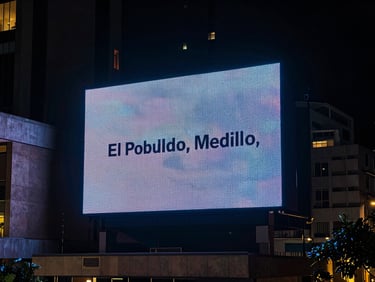 Cinematic 35mm photo of a premium outdoor LED screen in El Poblado, Medellín, surrounded by modern architecture, dramatic night lighting