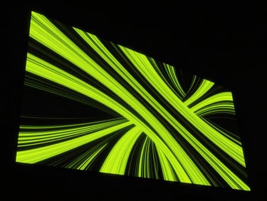 Wide dramatic angle of a premium digital screen in Bogotá displaying vibrant abstract generative art, high-contrast neon-lime highlights, deep obsidian night background.