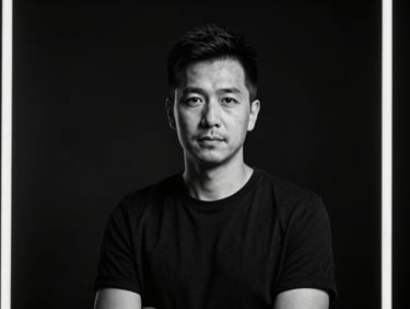 High-production-value black and white portrait of a creative director in a dark studio, cinematic high-contrast lighting, sharp focus, 35mm