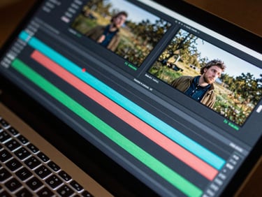 Close-up of a compositing timeline in post-production software, rendered 3D layers being merged with live footage, screen glow illuminating keyboard, overhead angle