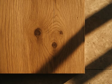 Close-up of solid oak timber grain, highlighting natural knots and a matte sand-toned finish.