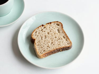 Artisanal sourdough sandwich on matte ceramic tableware, overhead flat-lay, bright minimalist food photography