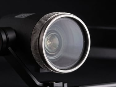 Macro shot of a Freewell drone filter mounted on a gimbal, showing the knurled metallic ring and pristine glass, sharp rim lighting against a dark background, 85mm.