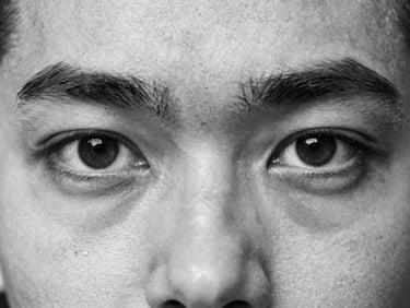 Extreme close-up of the same historical black and white portrait, meticulously restored, rich monochrome tones, sharp eye detail, no tears, 35mm macro.