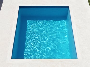 Symmetrical overhead shot of a minimalist swimming pool in Baghdad, crystal clear turquoise water reflecting bright midday sun, clean white concrete deck, 35mm