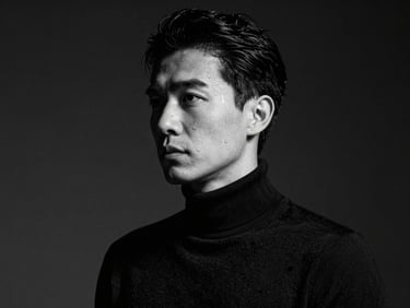 Stylized black and white studio portrait of a male creative director in a dark turtleneck, high-contrast side lighting, deep shadows, 35mm anamorphic lens.