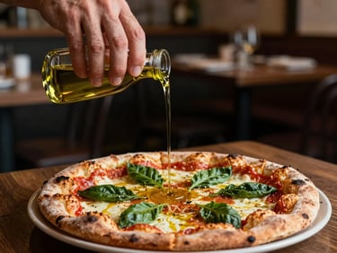 Close-up of hands pouring olive oil over a freshly baked sourdough pizza in a dim, moody restaurant interior, warm side-light, shallow depth of field.