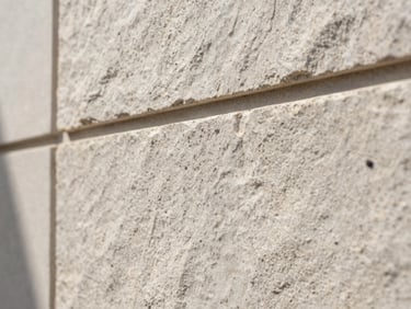 Macro crop of smooth raw stone wall texture, architectural clean lines, soft shadow.