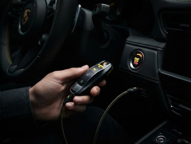 Macro close-up of a modern keyless car key being programmed inside a vehicle, high contrast, sharp focus, yellow accents, dramatic lighting
