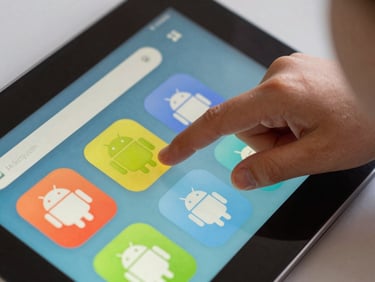 Extreme close-up of a child's finger tapping a brightly colored Android app interface on a tablet, natural indoor daylight, tight frame showing only the screen and small hand