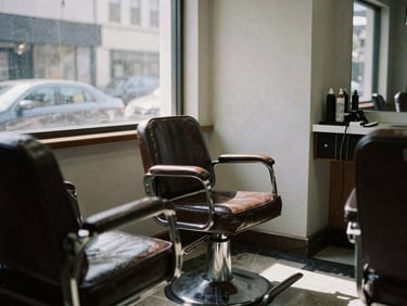 Classic old-school barbershop interior in SLP, leather chairs, harsh natural light through window