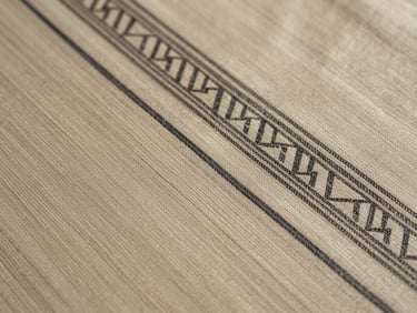 Extreme close-up of pure silk Patan Patola double-ikat textile, showing the mathematical precision of intersecting warp and weft threads under soft, directional daylight.