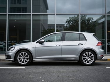 Silver daily hatchback parked against a modern glass facade, crisp reflections on polished metal, overcast daylight, sharp focus, 50mm