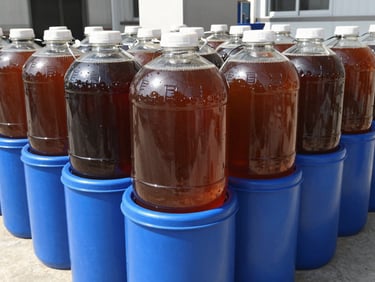 25-liter blue plastic drum for wood vinegar, clean industrial setting, bright natural daylight.