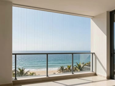 Architectural view from a high-rise apartment balcony looking out over the ocean, secured by ultra-thin vertical invisible grills, sun-drenched day