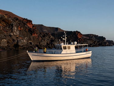 Wide environmental shot of a small tour boat at anchor in a calm Baja cove at blue hour, water glassy, volcanic rock cliffs in background, crew adjusting lines