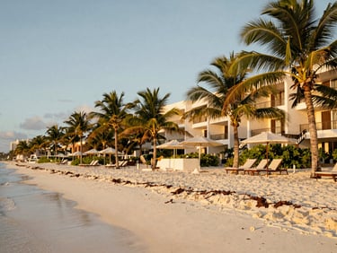 Luxurious beachfront resort in Cancun, white sand beach, palm trees, warm golden-hour light, 35mm, no people.