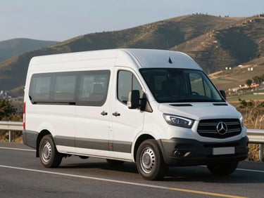 A spotless white premium multi-utility vehicle parked on a clean paved highway during bright morning light, spacious cabin visible through clear windows, scenic rolling hills in the background.