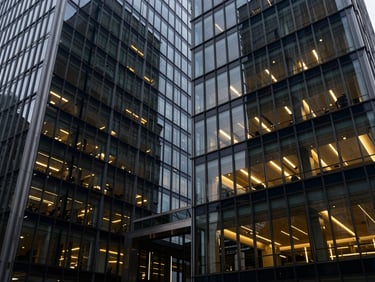 Abstract architectural lines of a modern corporate building, glass and steel, reflecting cool tones with warm accents from interior lighting, wide angle, 35mm