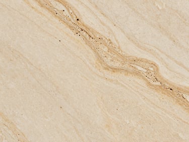 Close-up of travertine tile surface, natural vein patterns visible under raking side light, filled and sealed pores, warm cream and tan tones