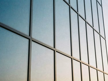 Close-up of architectural glass panels reflecting a calm blue sky, clean lines, high-trust aesthetic, 35mm film