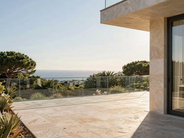 Exterior terrace in Mougins, natural stone paving, minimalist glass balustrade, overlooking Mediterranean greenery, golden hour sun.