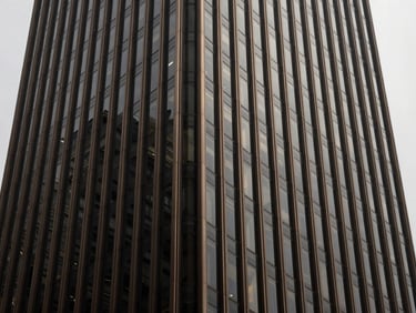Symmetrical close-up of a premium steel and glass office tower corner, sharp architectural shadows, overcast daylight