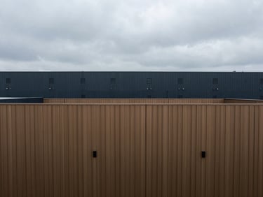 High-angle view of a clean, modern logistics facility with architectural lines, overcast sky