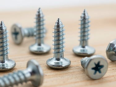 Macro close-up of industrial steel screws and heavy hardware components, metallic texture, sharp focus, overcast daylight, 35mm