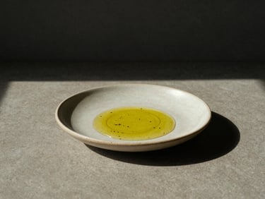 Minimalist food plating of a hemp-seed oil dish on a ceramic plate, harsh studio lighting, muted earth tones.