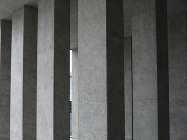 Abstract geometric pattern of concrete pillars in a modern office lobby, cool overcast daylight, soft grey tones, 35mm