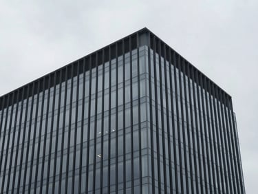 Stark overcast daylight illuminating the clean glass facade of a modern corporate headquarters, architectural angles, minimalist composition, 35mm